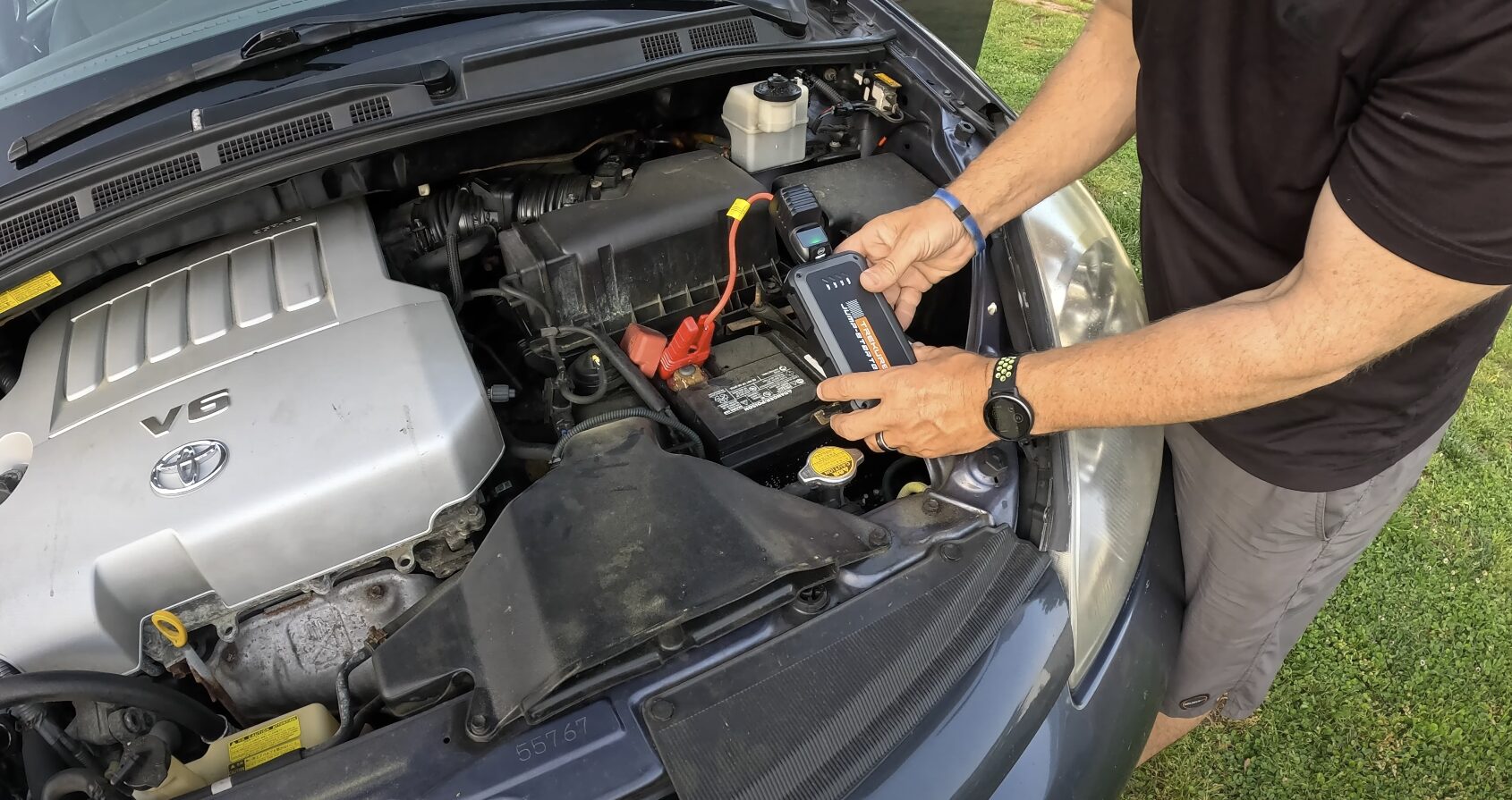Professional mechanic providing roadside assistance and battery jump start service